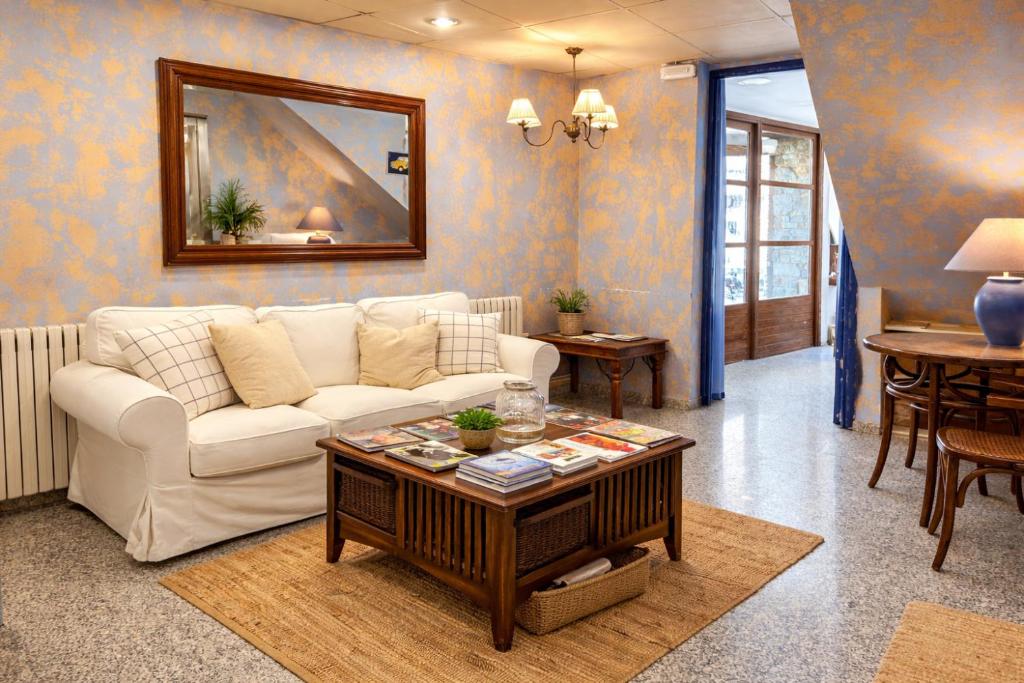 a living room with a white couch and a table at La Posada d'Àneu by RdA Hotels in Esterri d'Àneu