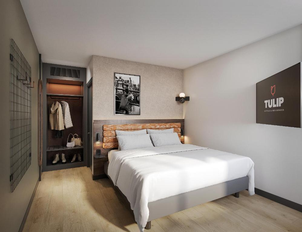 a bedroom with a large white bed and a closet at Campanile Hotel & Restaurant Gouda in Gouda