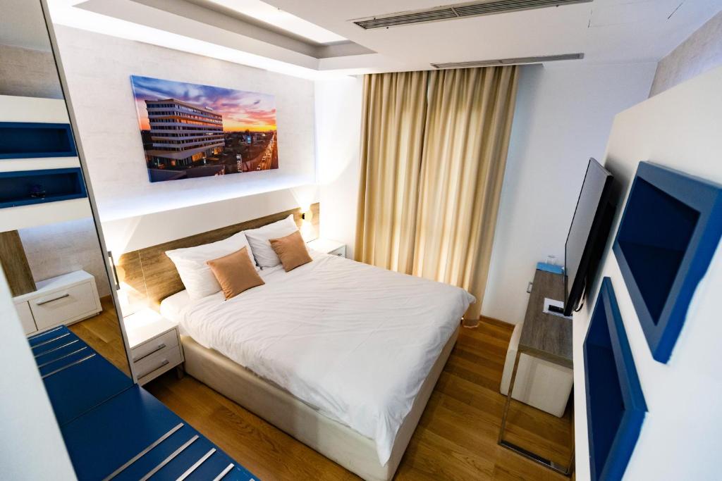a small bedroom with a bed and a tv at Rox in Modriča