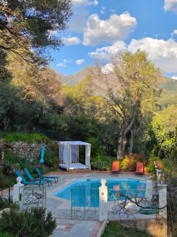 a swimming pool with chairs and a table at La licorne in Serriera