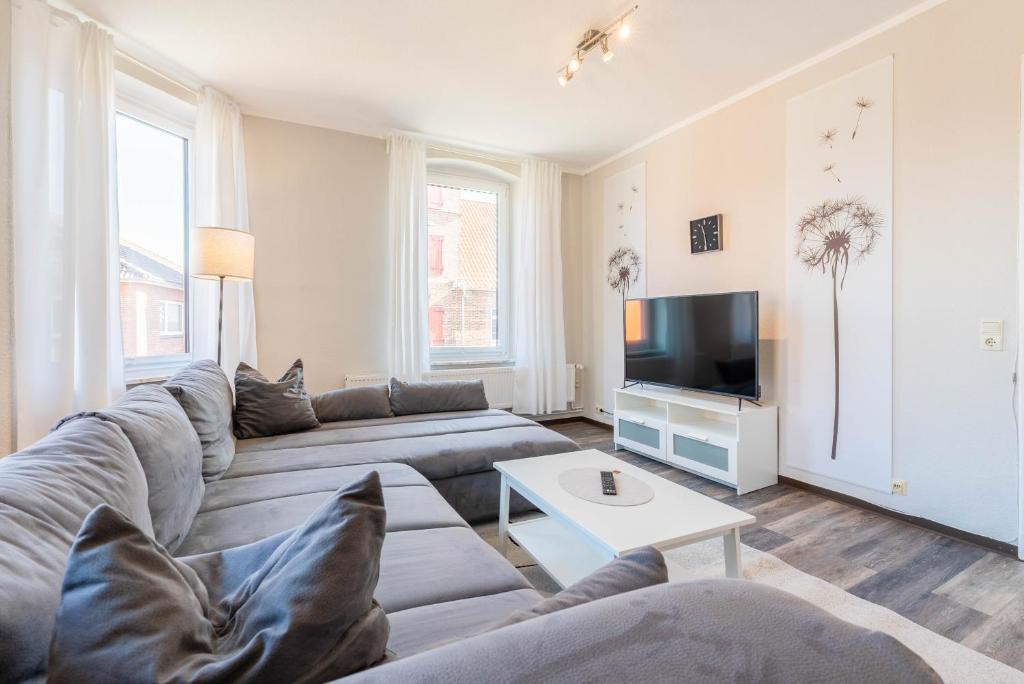 ein Wohnzimmer mit Sofa und Fernseher in der Unterkunft Hafencity Apartments in Tönning