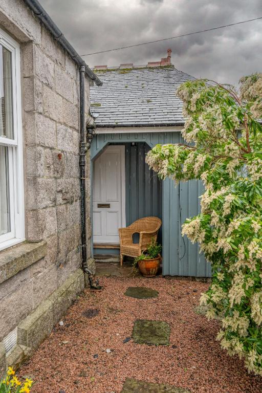 a blue garage with a white door and a bench at Firhurst in Aboyne