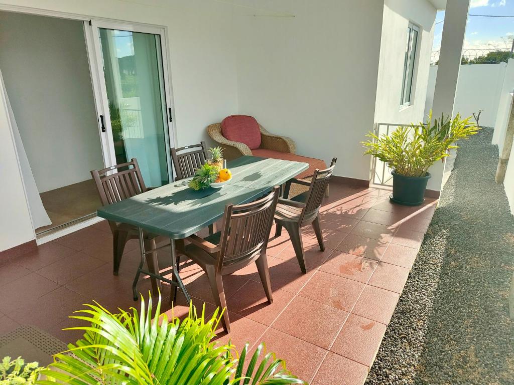 a green table and chairs on a patio at Noulakaz Maison proche Belle Mare marché de Flacq in Argy