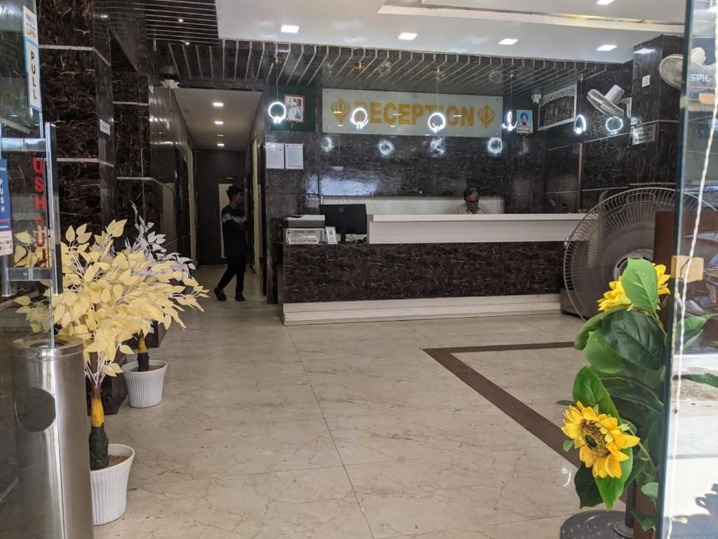 a lobby with flowers and a counter in a building at Hotel Priya Palace in Rānchī