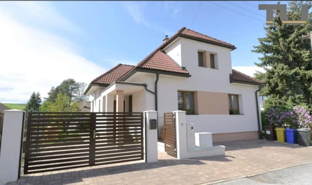 a white house with a wooden fence at Vila Vannet II in Liptovský Mikuláš