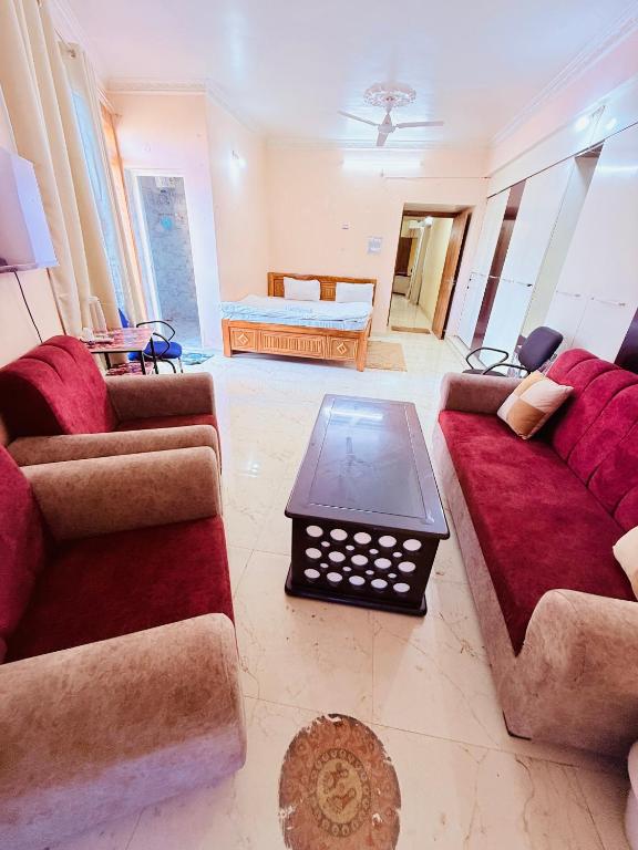 a living room with two couches and a table at Airport Sky Transit Suites in Rānchī