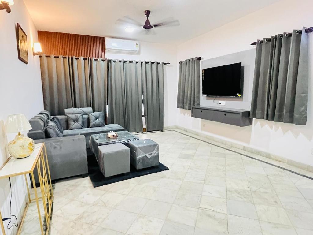 a living room with a couch and a flat screen tv at Traditional villa in Gurgaon