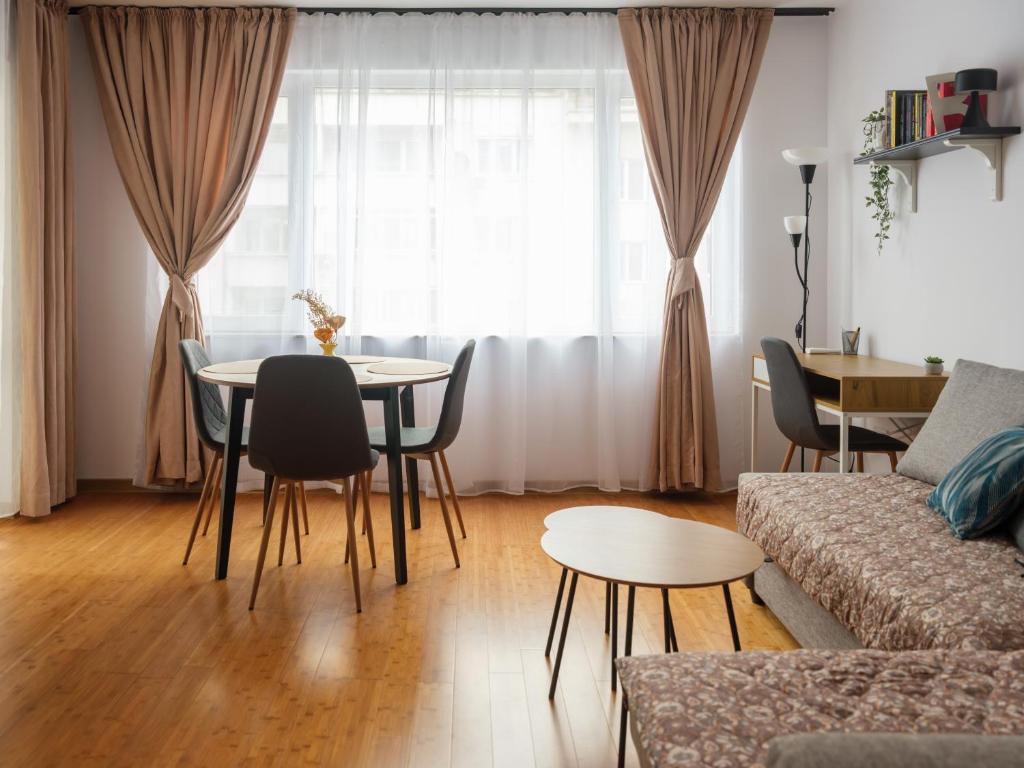 a living room with a table and chairs and a couch at Shazam Apartment Central, Stylish & Cozy near AUBG in Blagoevgrad