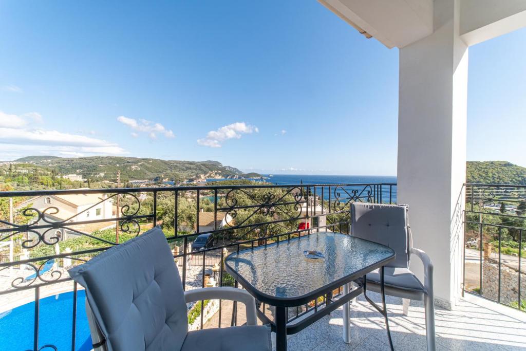 a balcony with a table and chairs and a view of the ocean at Captain Spiros Studios 2 in Paleokastritsa