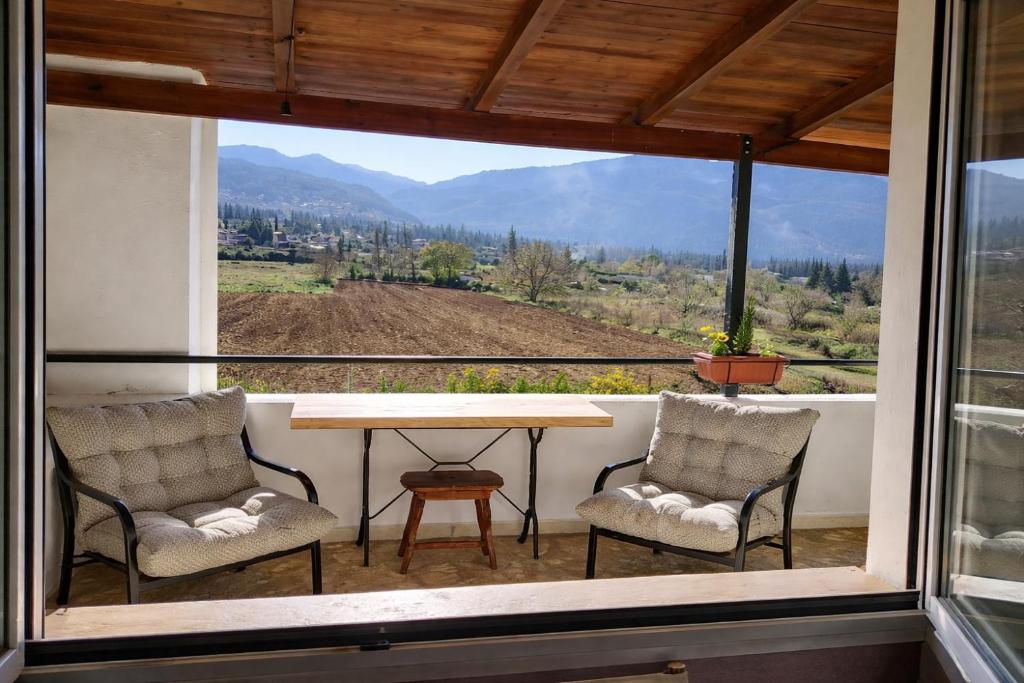 a room with a table and two chairs and a window at Villa Dorothy - Mountain View Retreat, Polydrosos in Delphi
