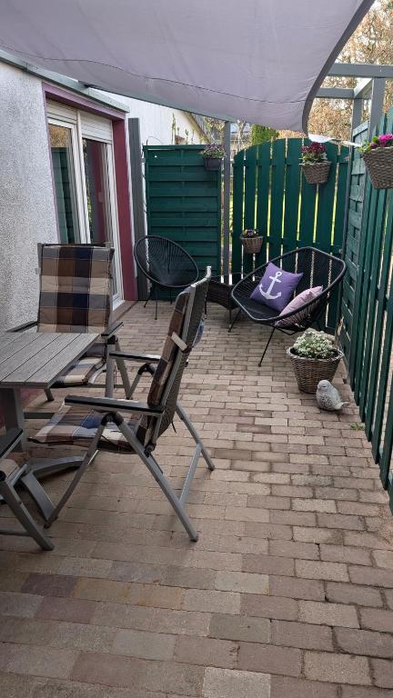 a patio with a table and chairs and an umbrella at Ferienwohnung Rumbeck in Hessisch Oldendorf