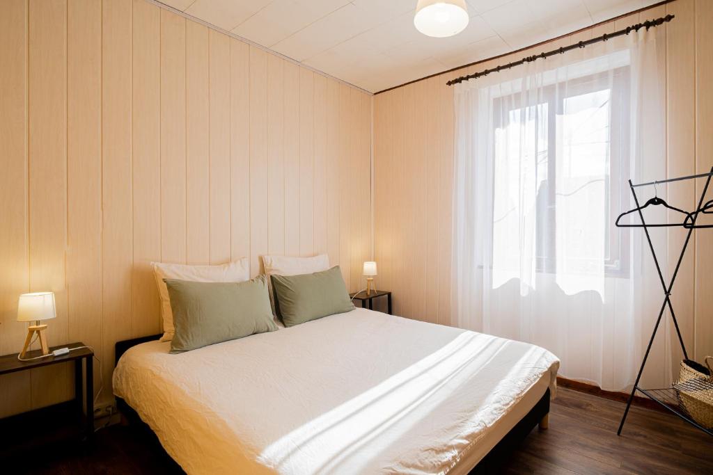 a bedroom with a white bed with a window at Le Cocon Alsacien Parking privé Espace repas BBQ in Ebersheim