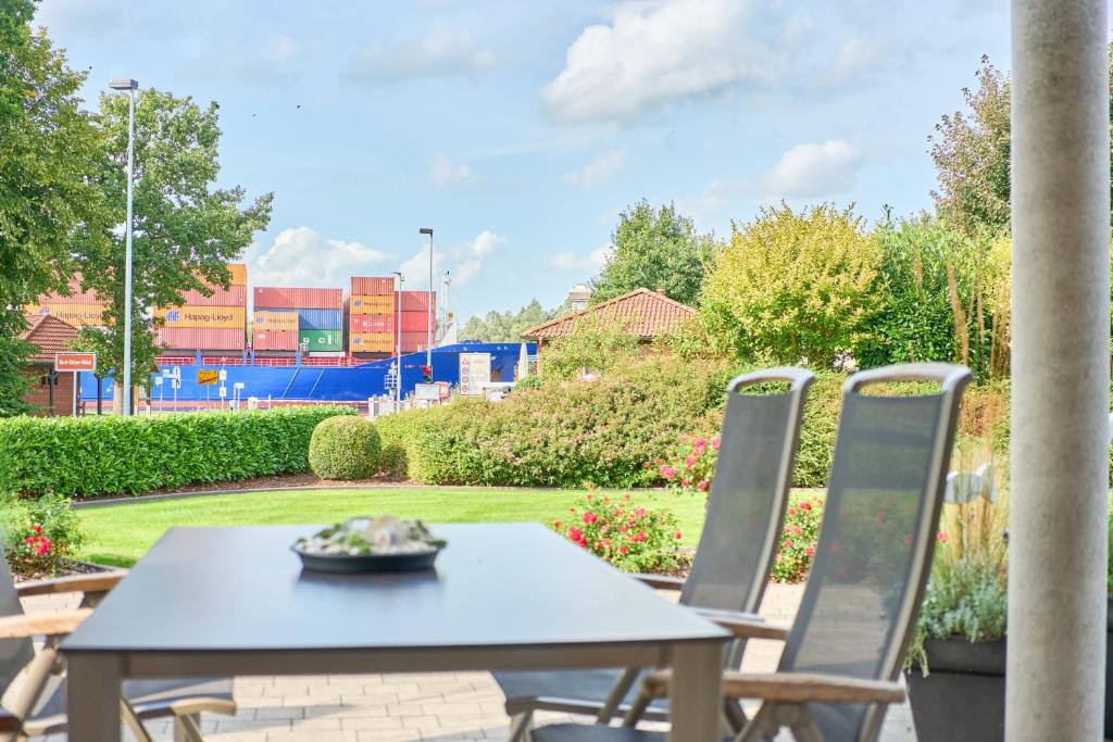 a table and chairs on a patio with a view of a ballpark at Villa Kanalblick, Schiffsdeck in Oldenbüttel