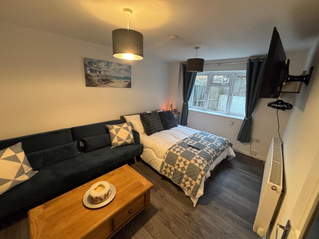 a living room with a couch and a bed at Neptune Nights in Pontnewynydd