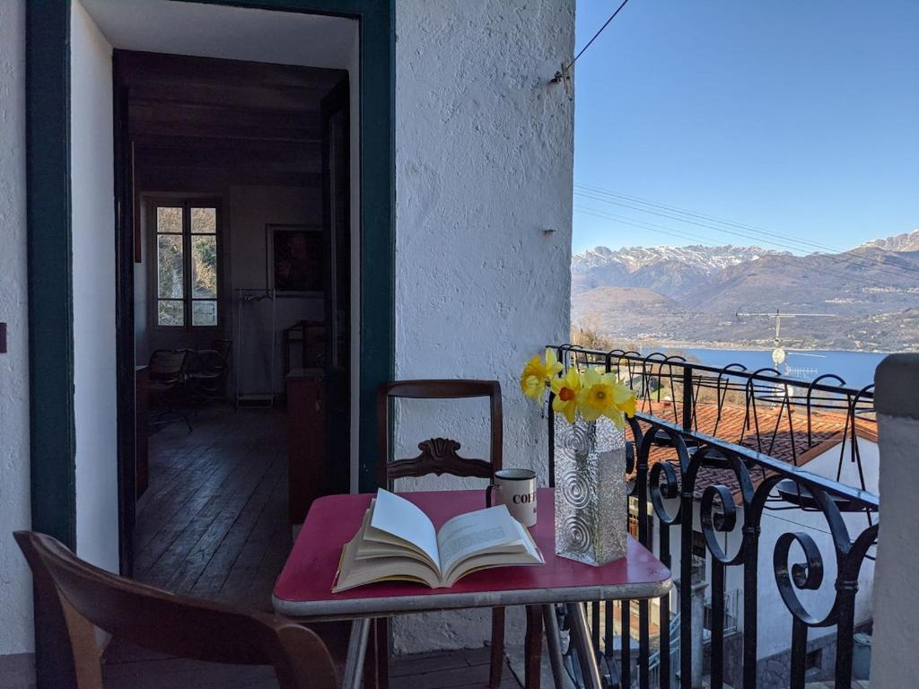 a table with a book and a vase of flowers on a balcony at The Rooster House A Study in Green in Someraro