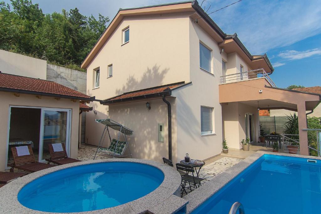a swimming pool in front of a house at Holiday Home Vele with pool in Vrgorac