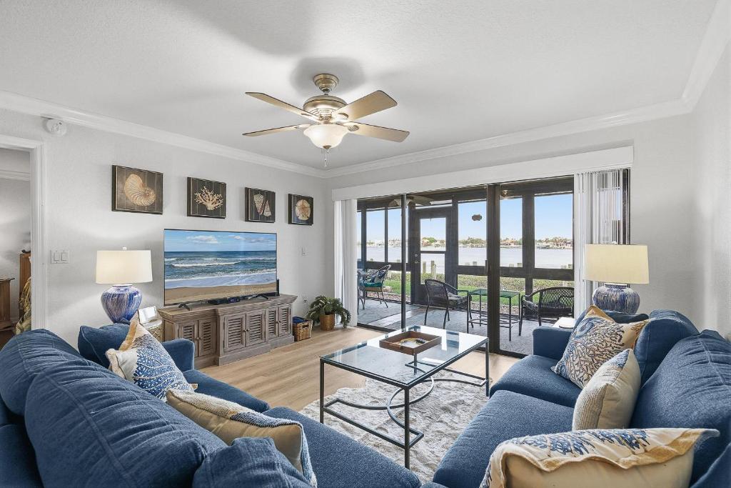a living room with a blue couch and a tv at Bouchelle Island 102 in New Smyrna Beach