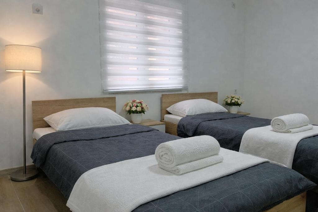 a bedroom with two beds with towels on them at Nina Apartments in Negotin