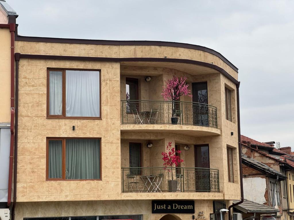 a building with two balconies with flowers on it at Just a Dream - guest apartments in Troyan