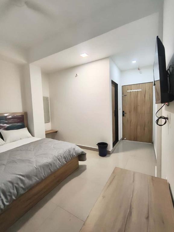 a bedroom with a bed and a flat screen tv at Hotel The Skyluxe in Agra