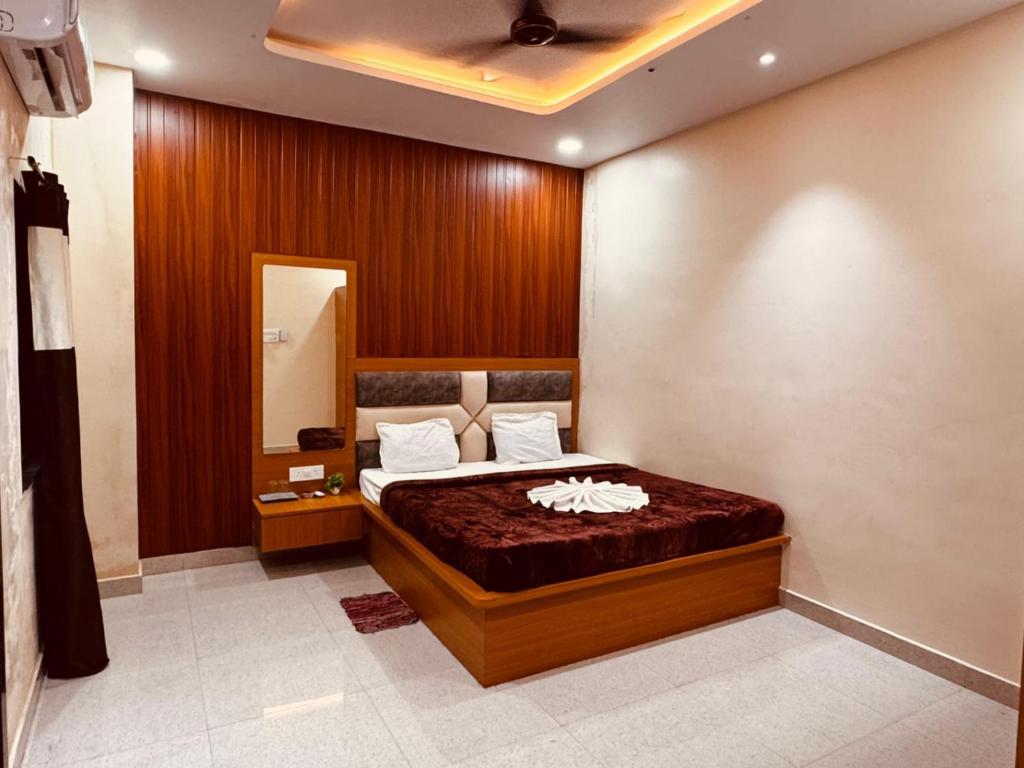 a bedroom with a bed with a wooden wall at Hotel shri Sudama in Ambikāpur