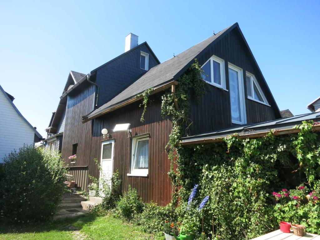 a house with a black roof and ivy at Wanderunterkunft in Frauenwald in Frauenwald