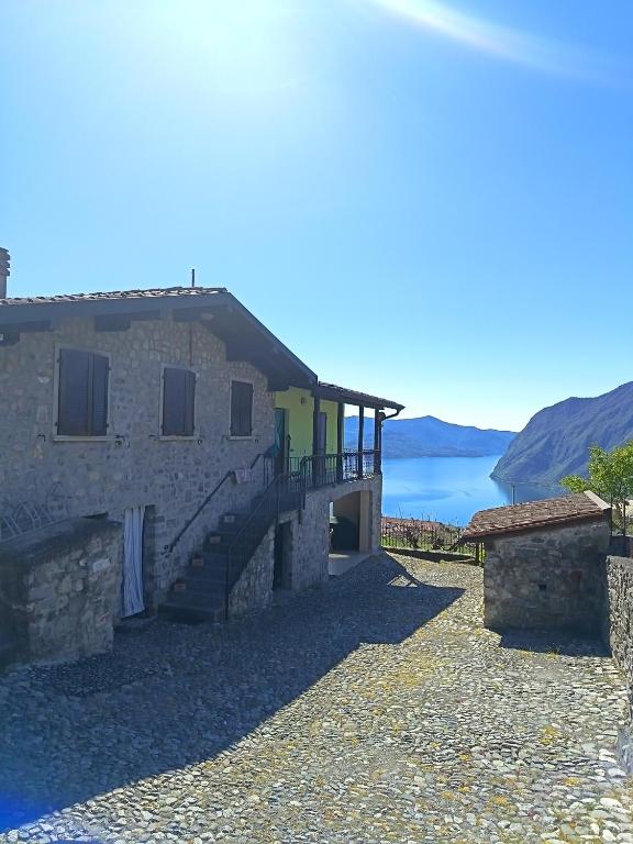 a stone house with a view of the water at Gringo's Paradise apartment in Solto Collina