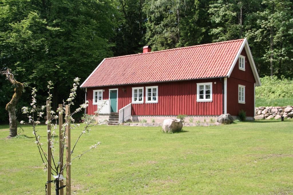 Svartrå的住宿－Wråen Svartrå，红色的房子,在田野上有一个红色屋顶