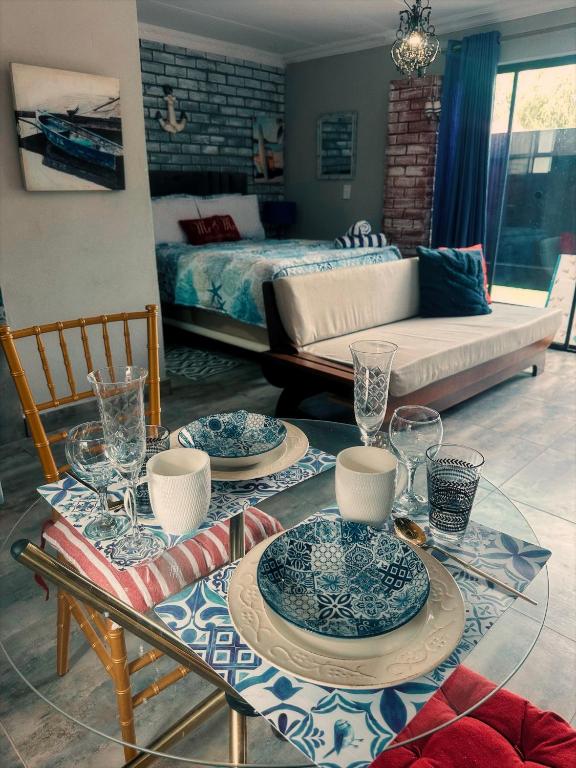 a living room with a table with plates and glasses at Ocean gate in Hartbeespoort