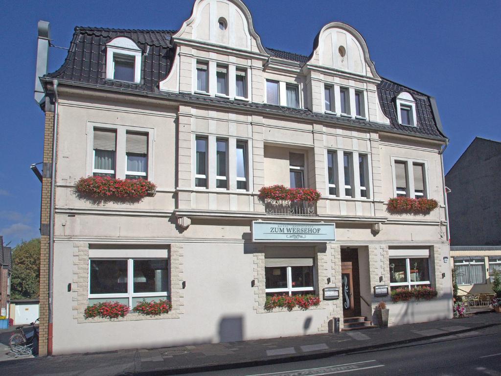 a white building with flower boxes on the windows at Hotel Zum Wersehof in Ahlen