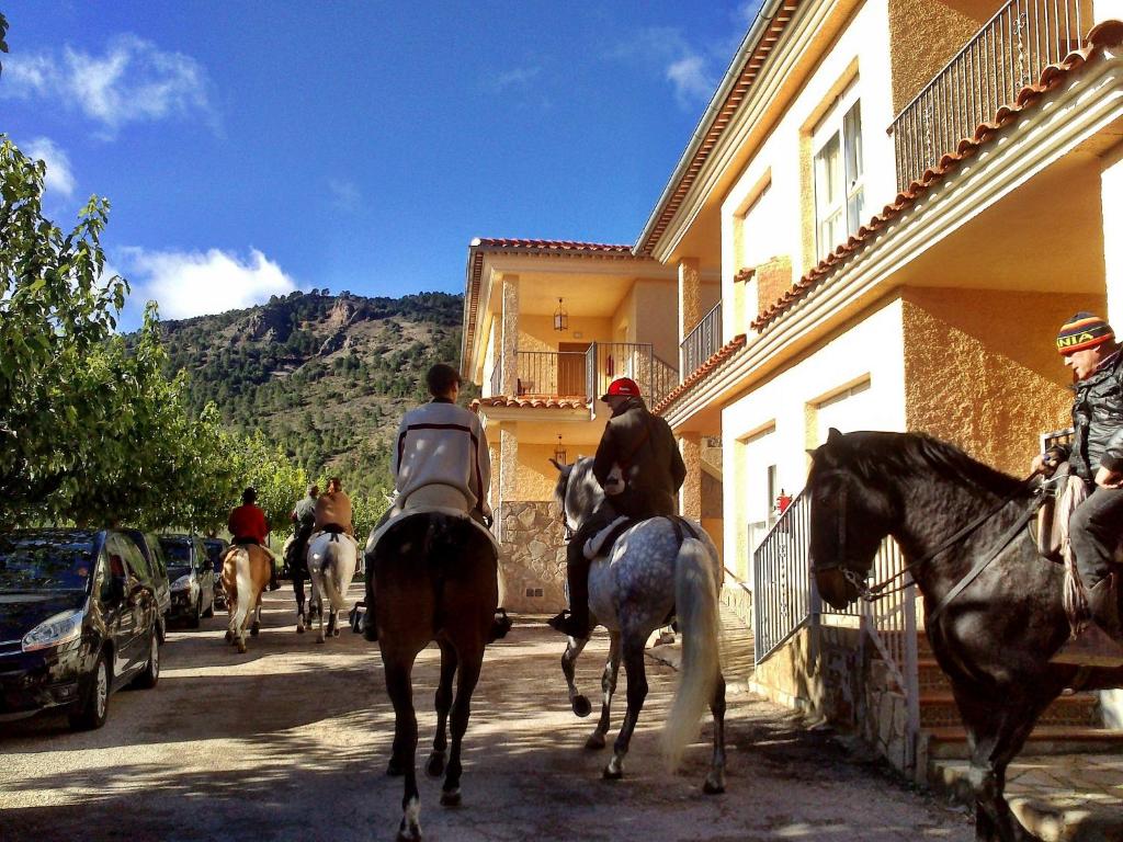 a group of people riding horses down a street at Apartamentos rurales Casas de Haches in Las Casas de Haches