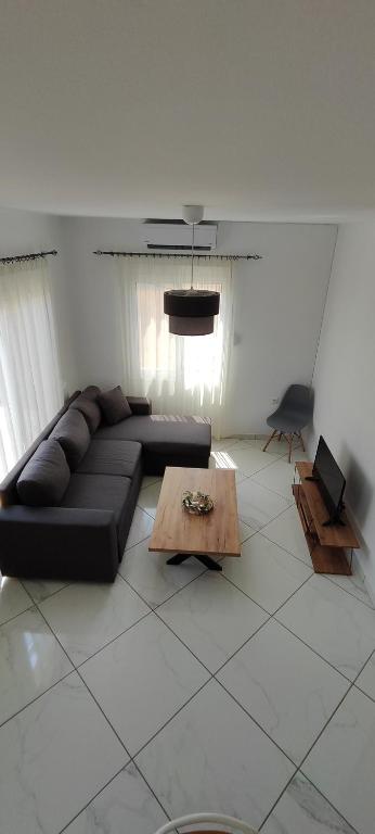 a living room with a black couch and a table at Dafnonas House - Bright & Modern in Leonidio