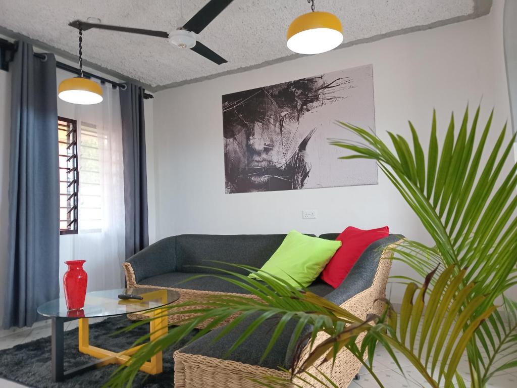a living room with a couch and a plant at TN Apartments Adina in Diani Beach