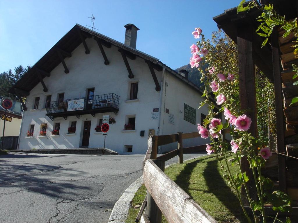 a white building with a fence and pink flowers at Chalet-Ski-Station in Chamonix