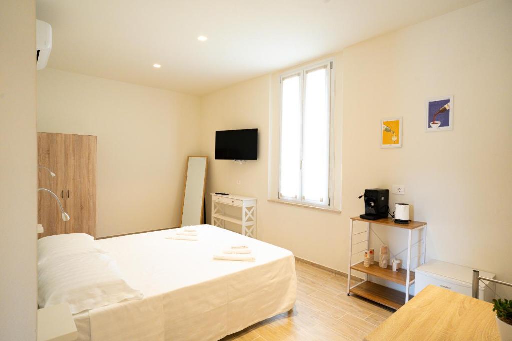 a bedroom with a white bed and a window at Locanda dell Angelo in Piacenza