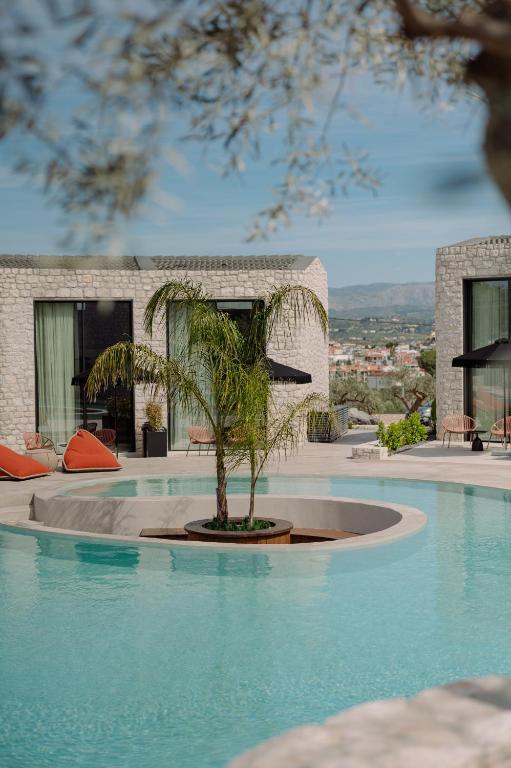 a swimming pool with a tree in the middle of it at Kyklio Pavilions in Nafplio