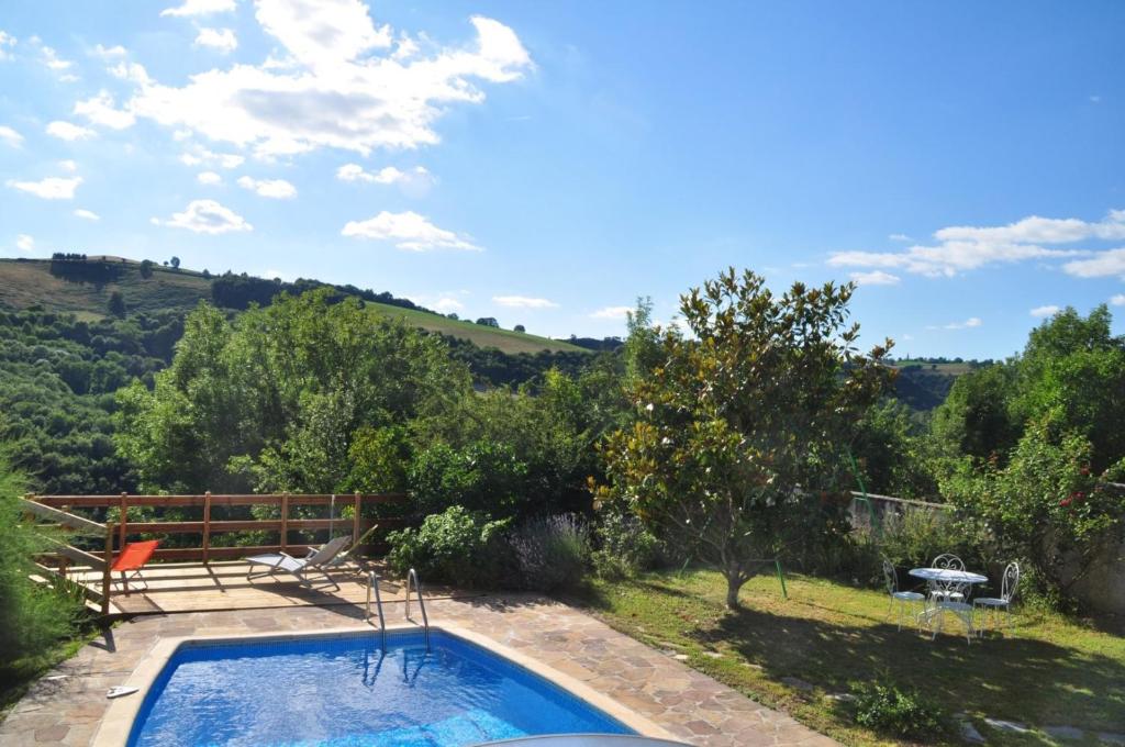 a swimming pool in a garden with a view at Gite Chez Lucien in Trébas