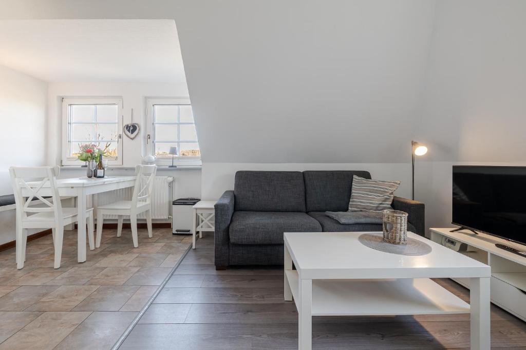a living room with a couch and a table at Sonnenaufgang in Süderende