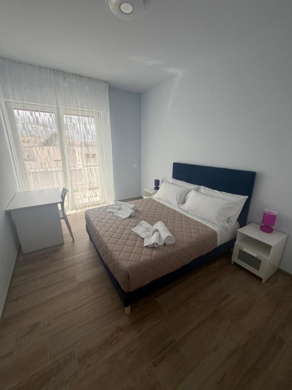 a bedroom with a large bed and a window at Vale House in Monopoli