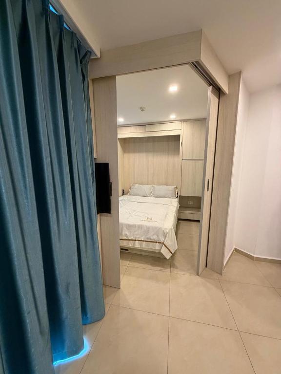 a bedroom with a bed and a blue curtain at City Garden Olympus Premier By Vacation Vibes in Pattaya South