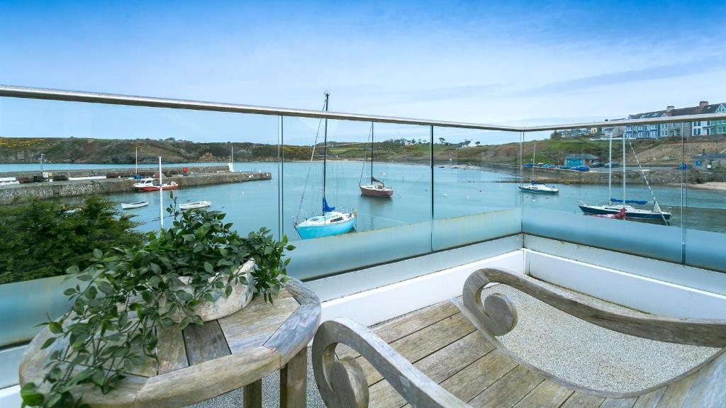 a balcony with a bench and a view of a harbor at Thalassa in Cemaes Bay