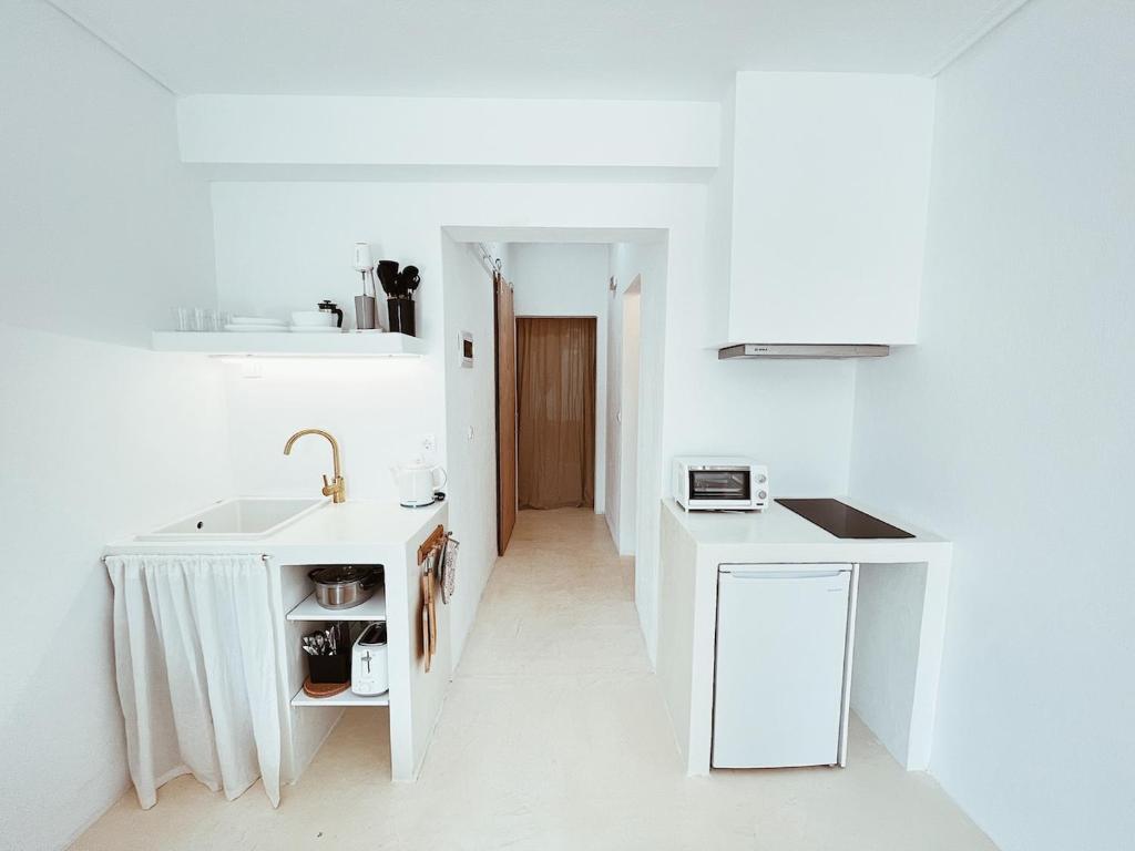 a white kitchen with a sink and a counter at Sand & Sea II in Neo Klima