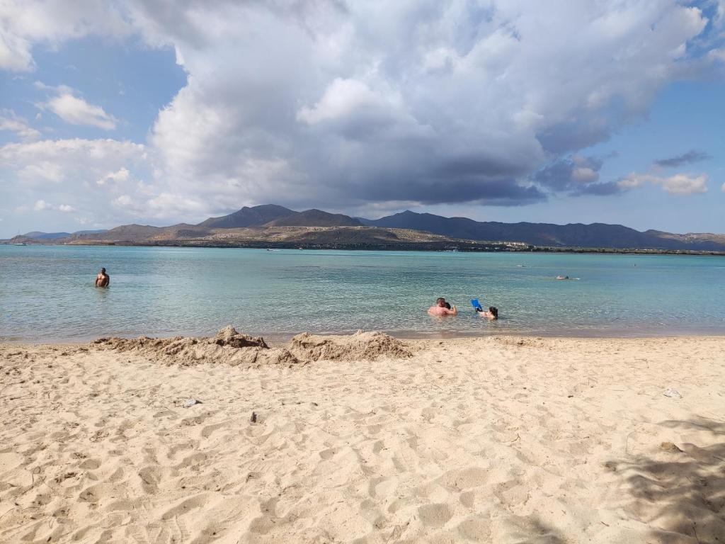 a group of people in the water at a beach at Almiriki- Ground Floor Seafront Studio in Elafonisos