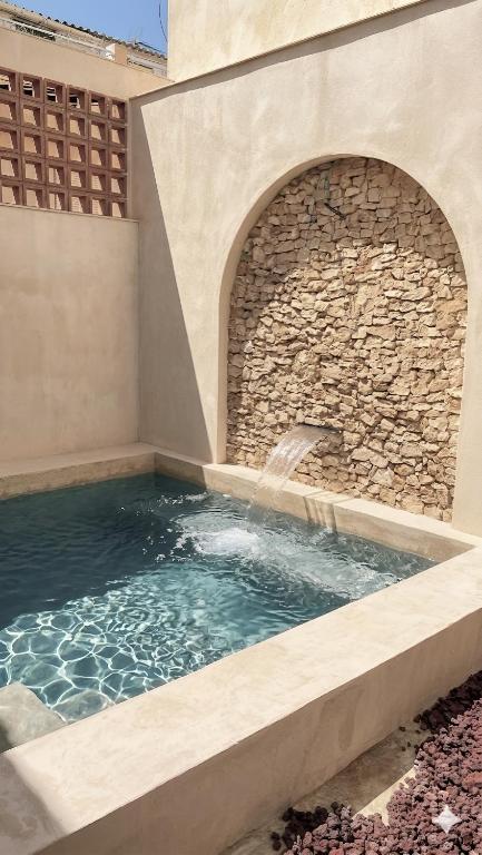 a swimming pool with a water fountain in a building at Suite ideal para escapadas romanticas in Bullas