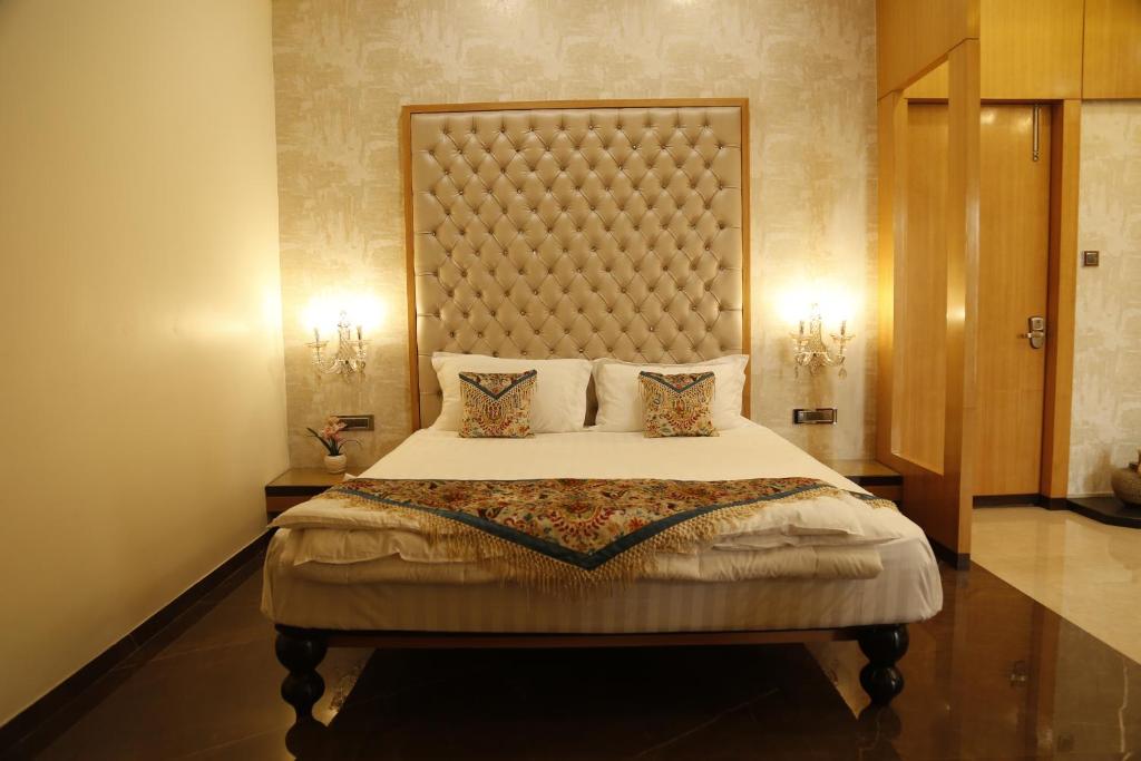 a bedroom with a large bed with a large headboard at Hotel Jannat Celebration in Wani