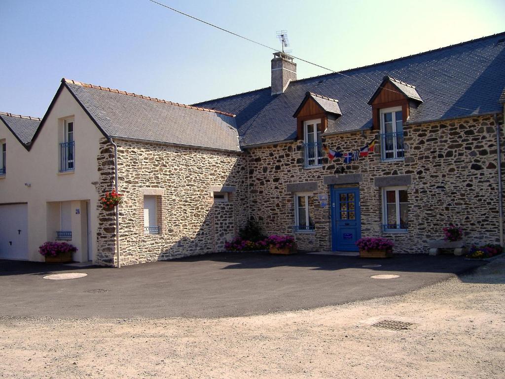 a large stone building with a blue door at La Grande Mare in Saint-Benoît-des-Ondes