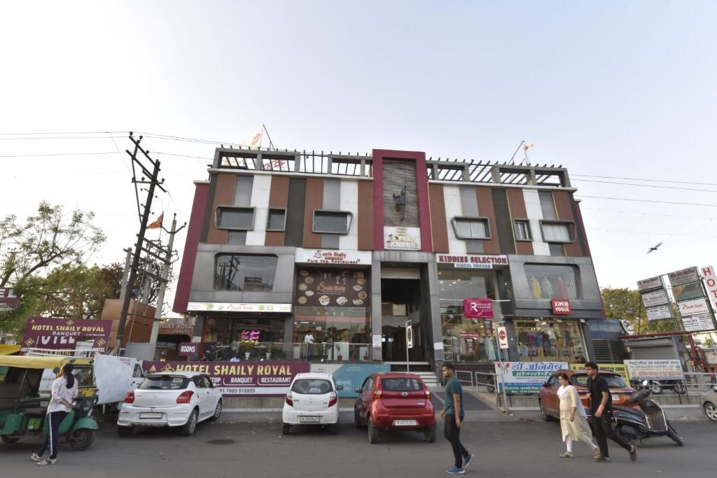 a building with cars parked in front of it at Hotel Shaily Royal in Kota