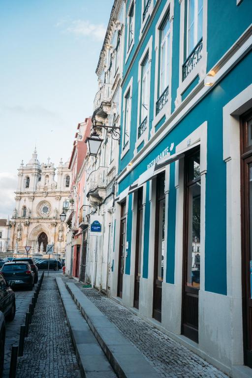 a cobblestone street in a city with buildings at Corações Unidos "A Pensão" in Alcobaça