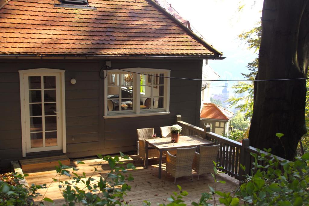 ein kleines Haus mit einem Tisch und Stühlen auf einer Terrasse in der Unterkunft Villa Sonnenburg Gästehaus in Rathmannsdorf