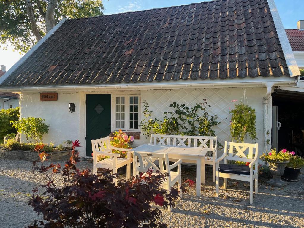 a white house with a table and chairs in front of it at Eldhuset in Stavanger